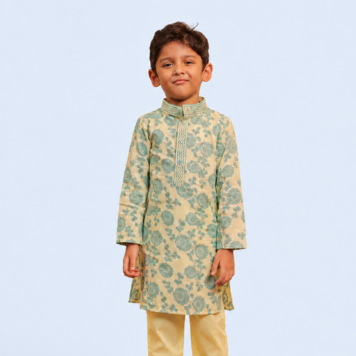 A young boy modeling a traditional Indian outfit consisting of a light green and beige floral printed kurta with yellow trousers, standing against a solid light blue background.
