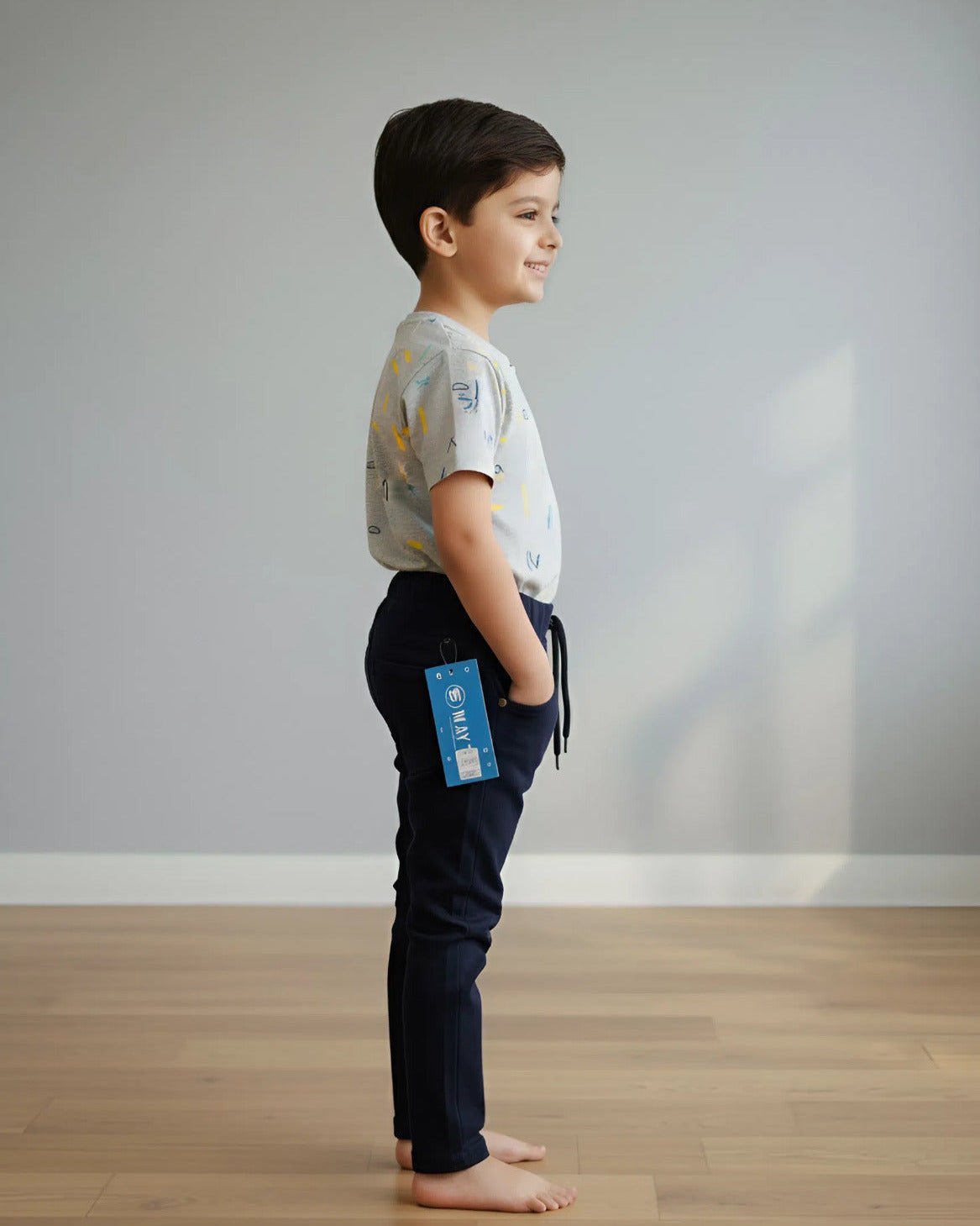 Child standing on a wooden floor with a plain background