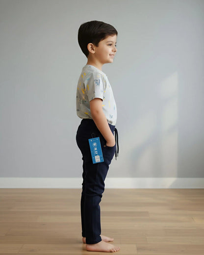 Child standing on a wooden floor with a plain background